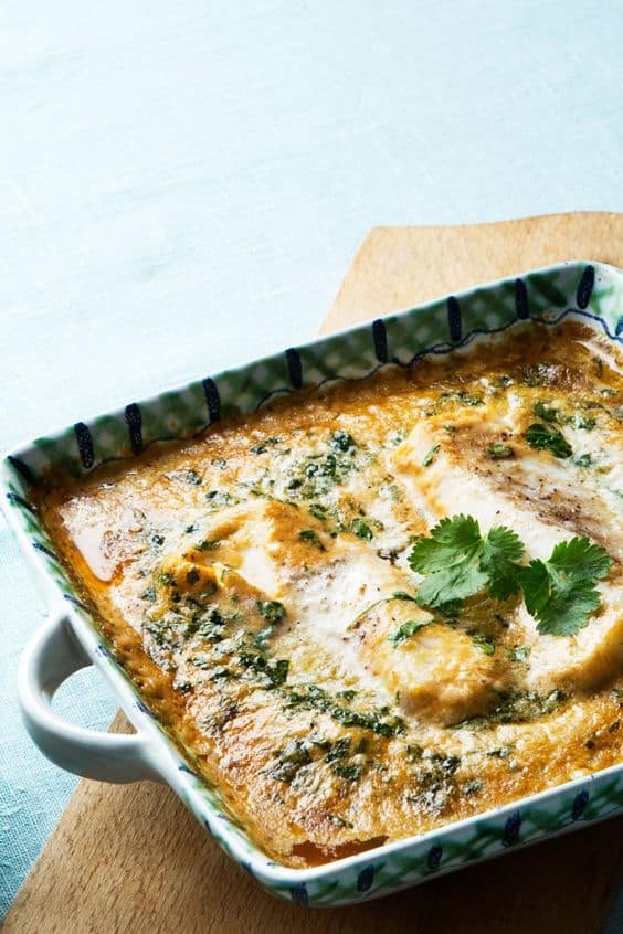 Thai keto fish curry topped with fresh cilantro in a square serving dish with a blue background.