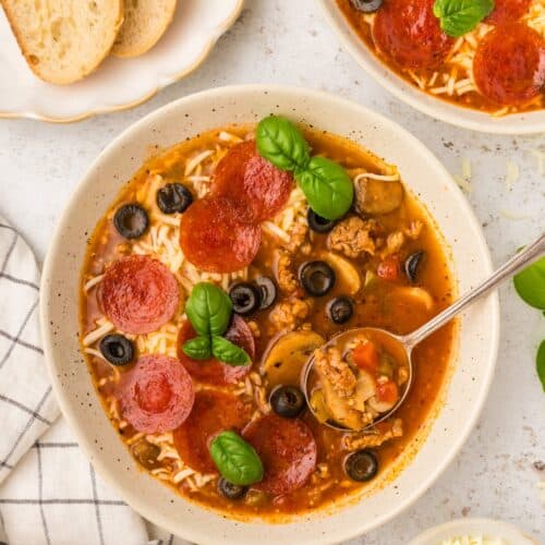 Pizza Soup served in bowls with bread.