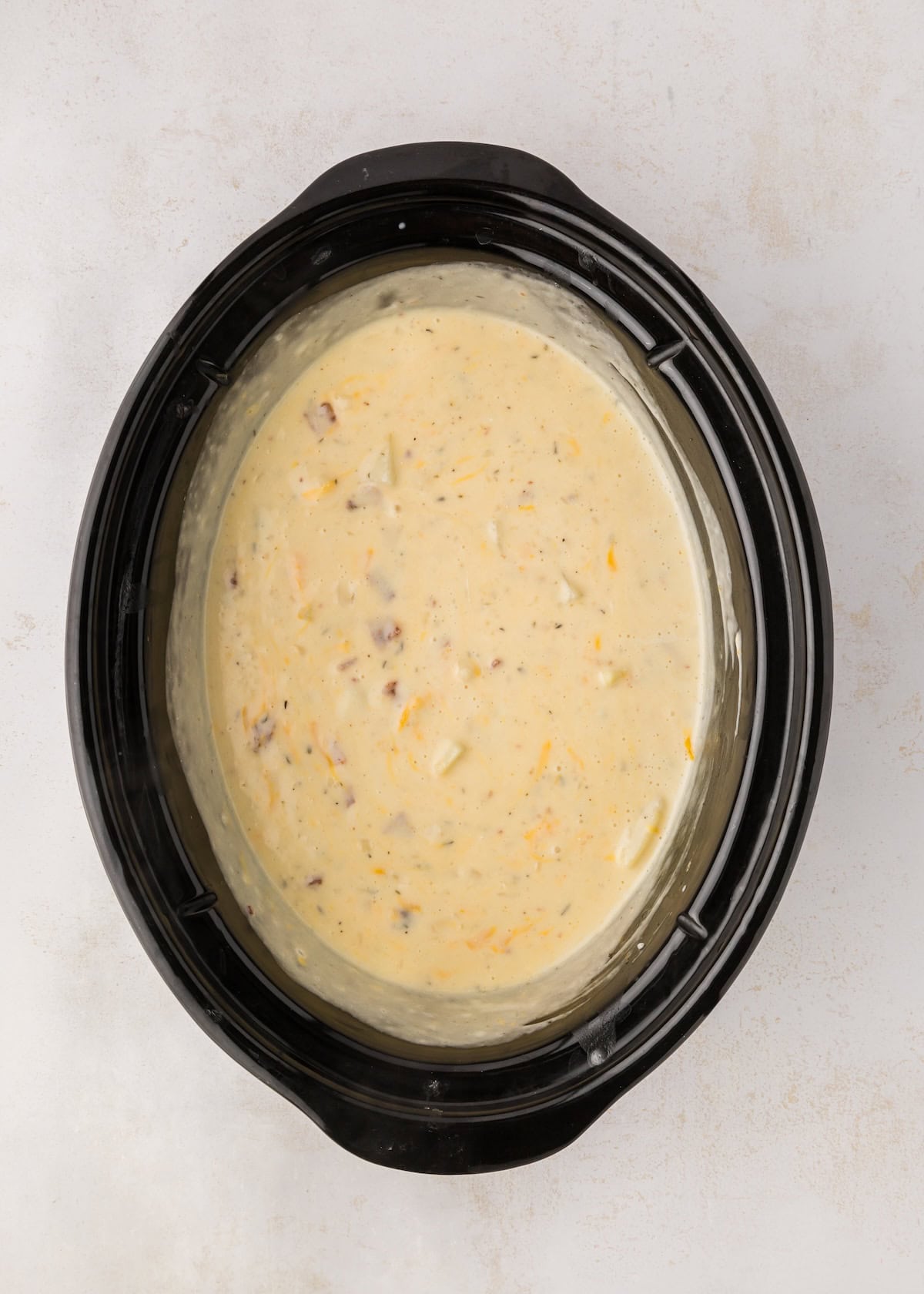 Crockpot soup with added bacon, heavy cream, sour cream, and cheddar cheese.