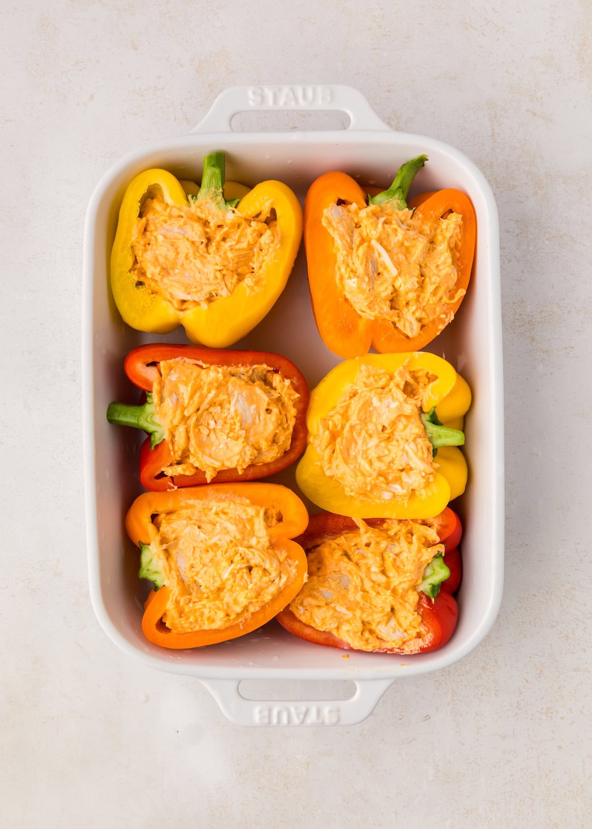 Buffalo Chicken Stuffed Peppers with creamy filling in a white baking dish, ready to serve.