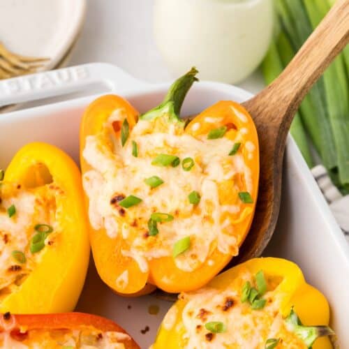 buffalo chicken stuffed peppers garnished with scallions in dish