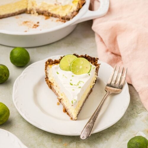 Slice of Key Lime Pie on a white dish.
