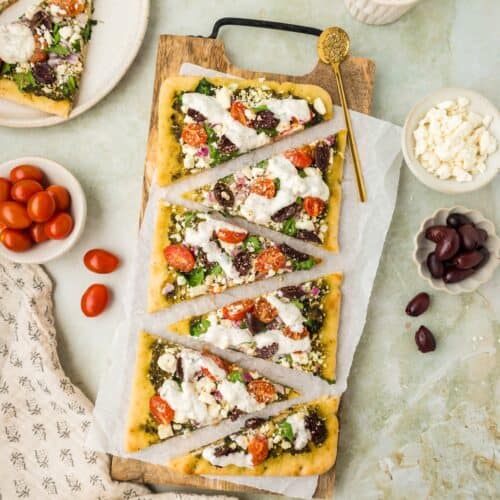 Overhead shot of Greek Flatbreads on a wooden board.
