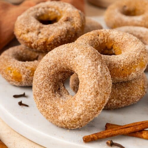 Pumpkin Spice Donuts served, with a cinnamon stick in the foreground.