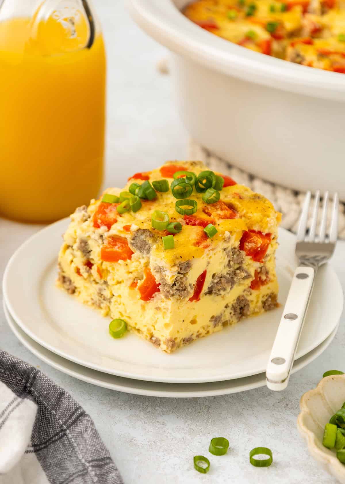A piece of breakfast casserole with a white fork on a small plate.