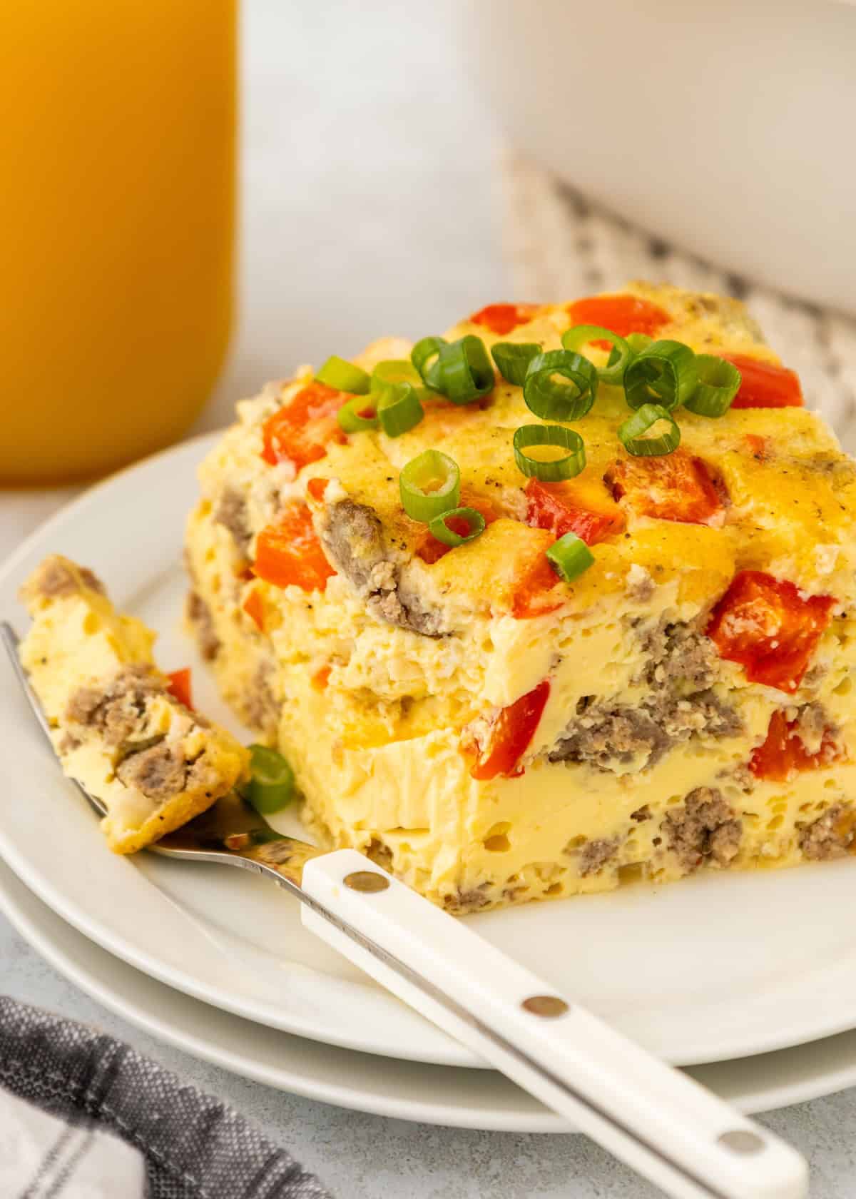 A piece of breakfast casserole with a fork on a small plate.