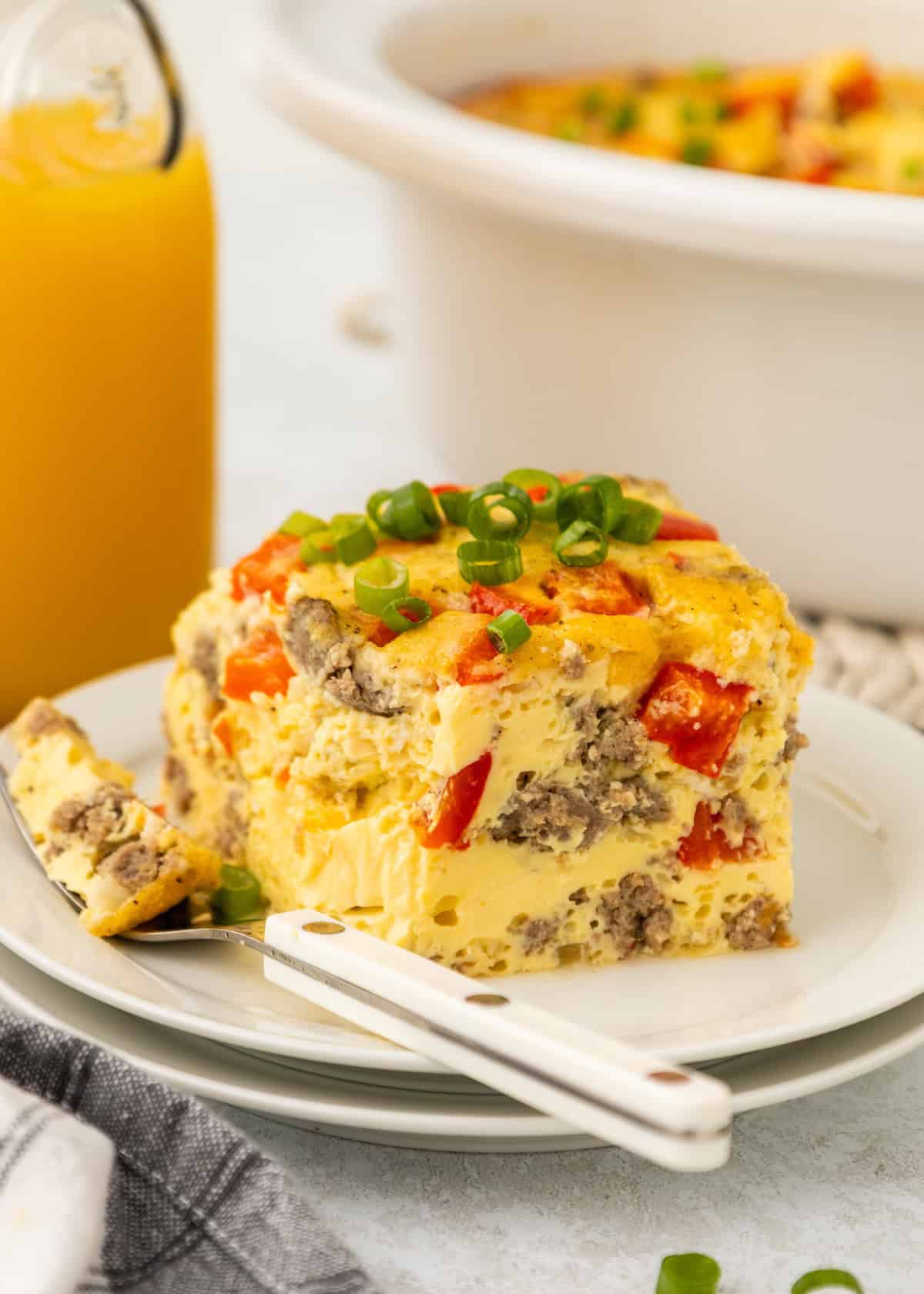 A piece of breakfast casserole with a fork on a small plate.