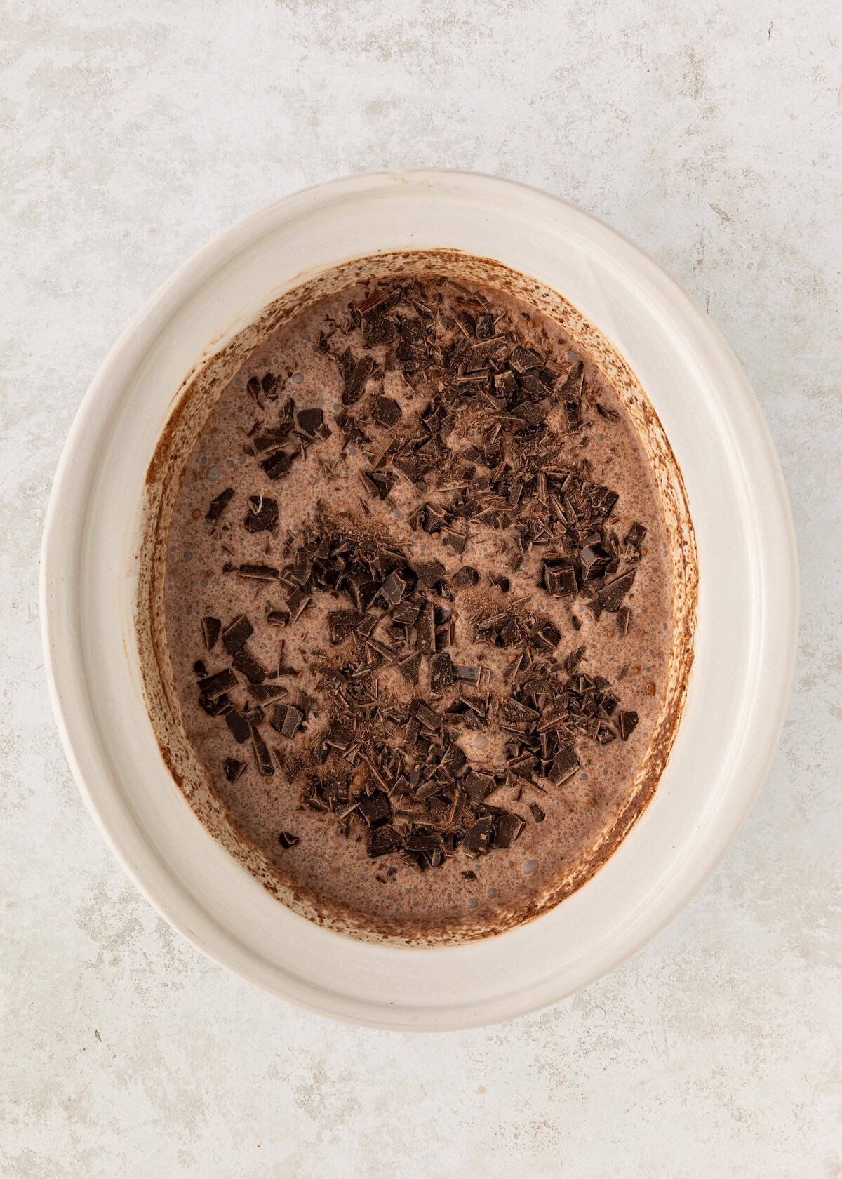 A white bowl with chocolate shavings on top of a creamy mixture.