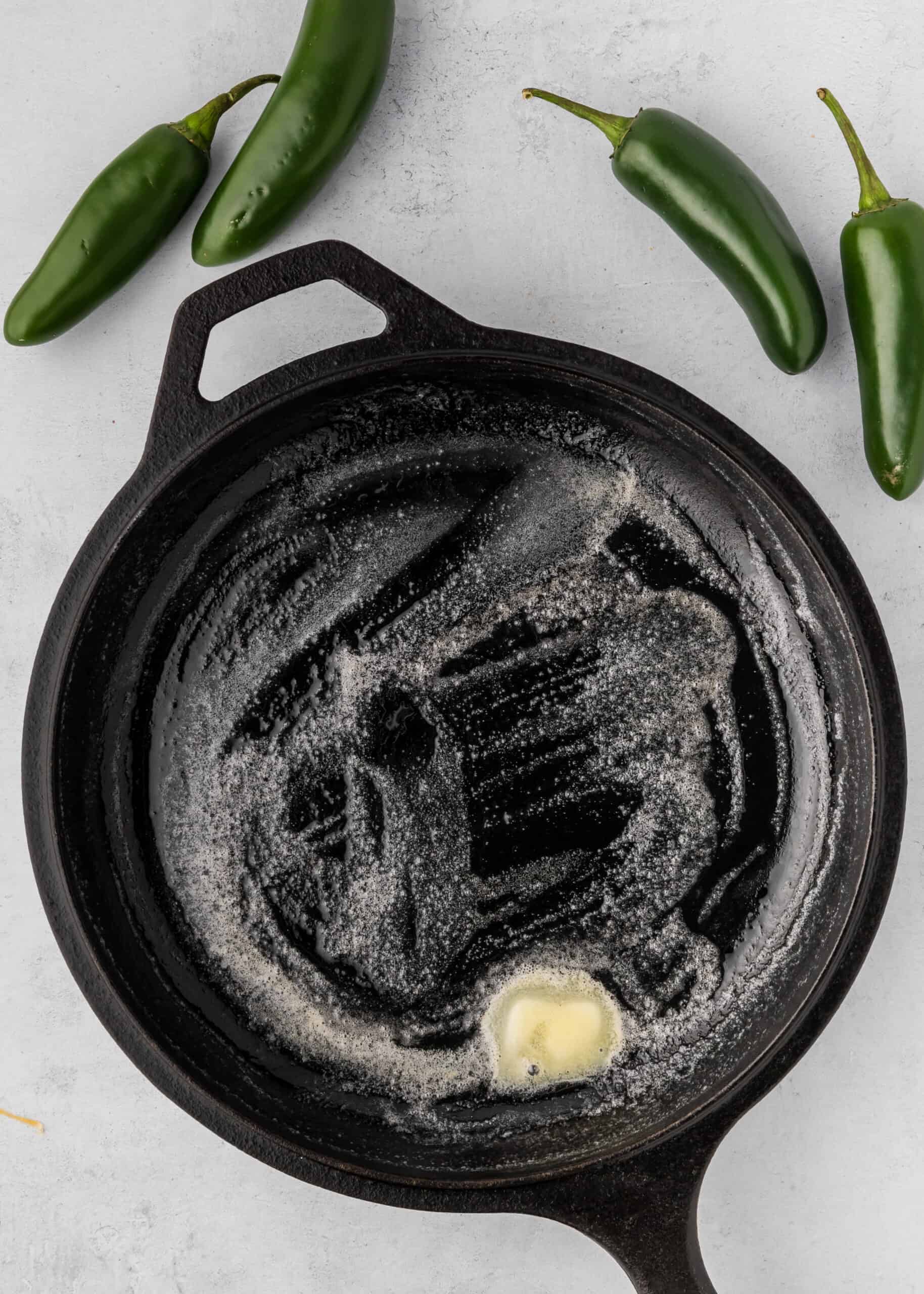 Melted butter in a cast iron skillet, perfect for Jalapeño Cheddar Cornbread.
