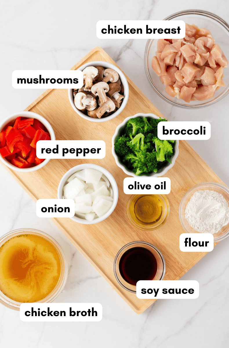 Assorted labeled Chicken Stir Fry ingredients, neatly arranged on a wooden tray.