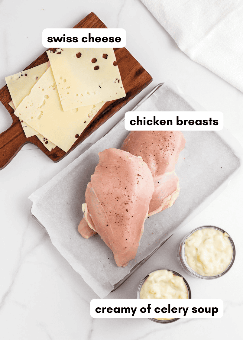 Chicken breasts, slices of Swiss cheese, and creamy celery soup on a white surface, labeled.