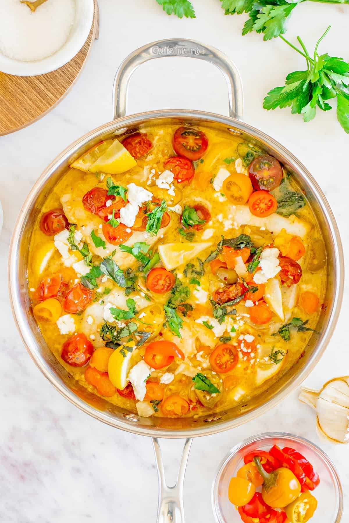 A pot of soup with vegetables and cheese.