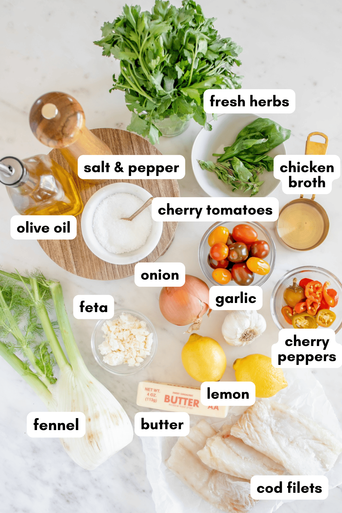 Top-down view of labeled ingredients for a fish dish, including herbs, fennel, lemon, and cod filets.