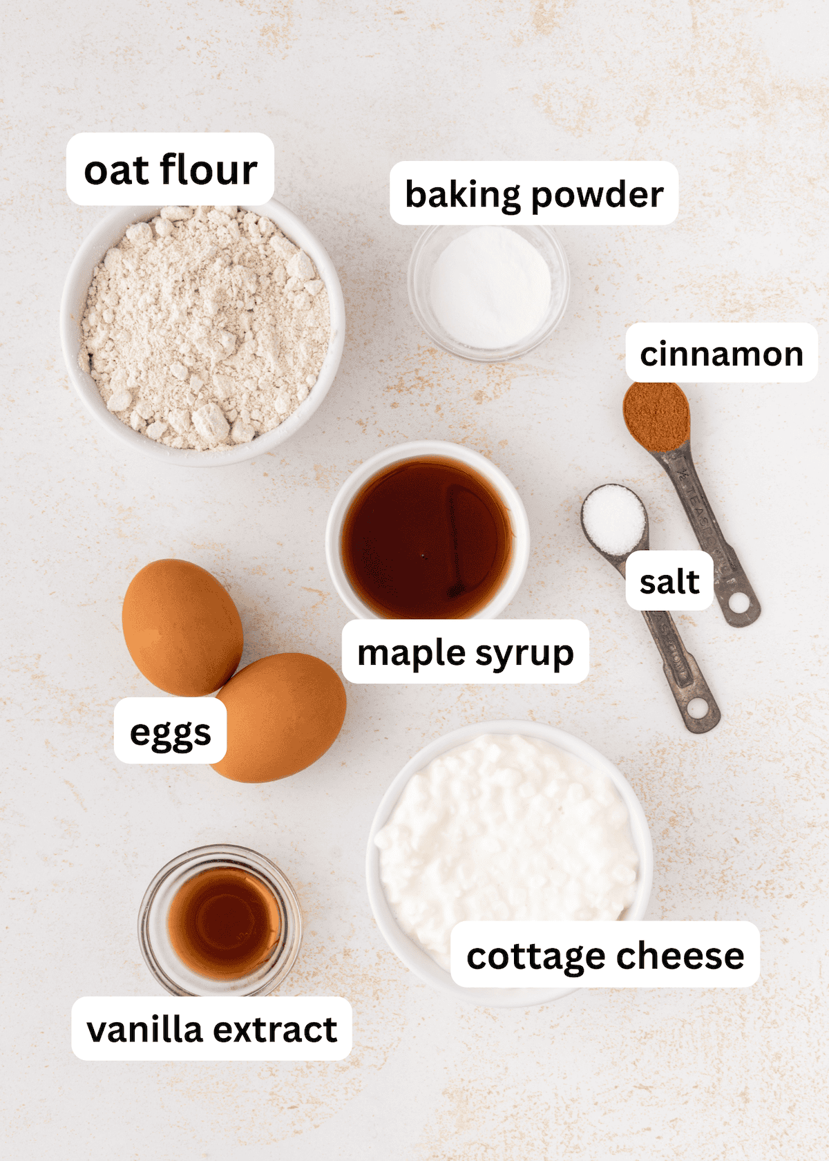 Labeled ingredients for a recipe, including eggs, oat flour, cottage cheese, and spices.
