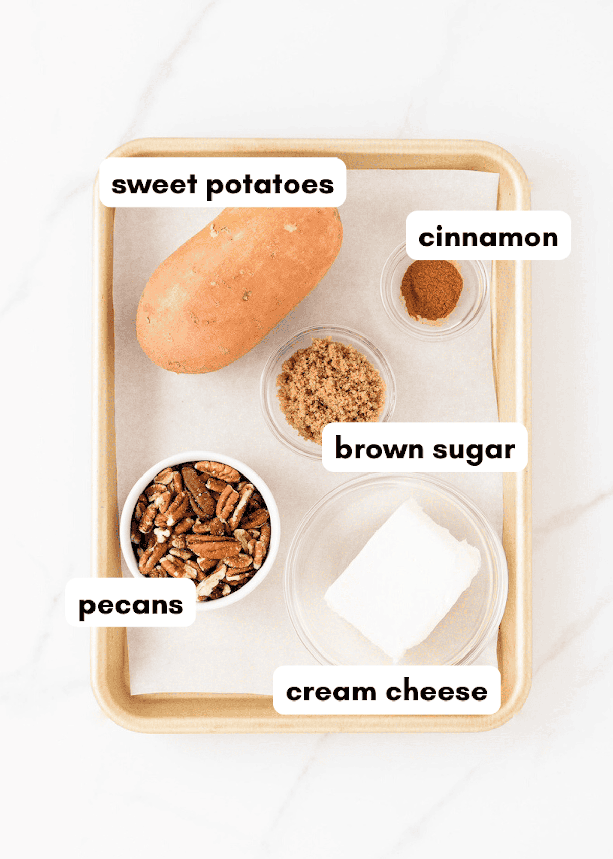 A tray with sweet potato, pecans, cream cheese, brown sugar, and cinnamon in bowls.