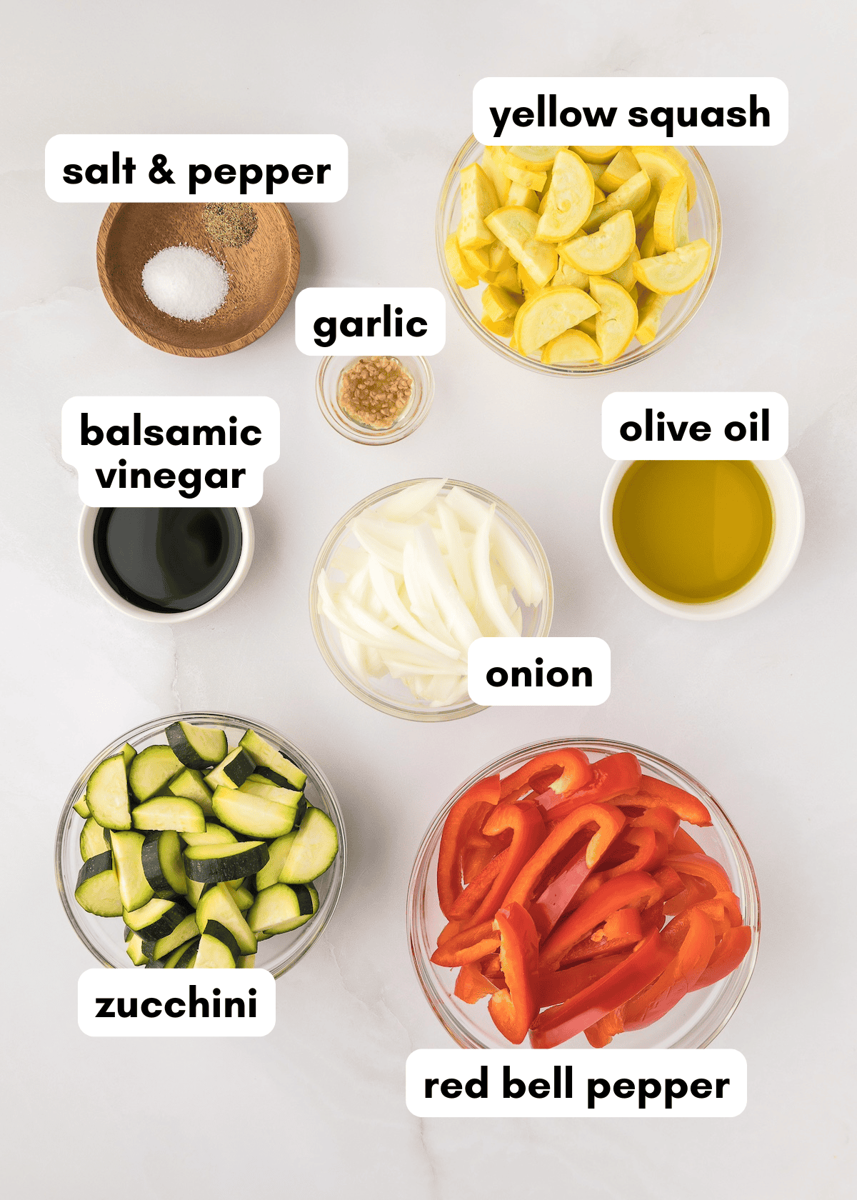 Bowls of balsamic roasted vegetables with yellow squash, zucchini, peppers, onion, and seasonings.