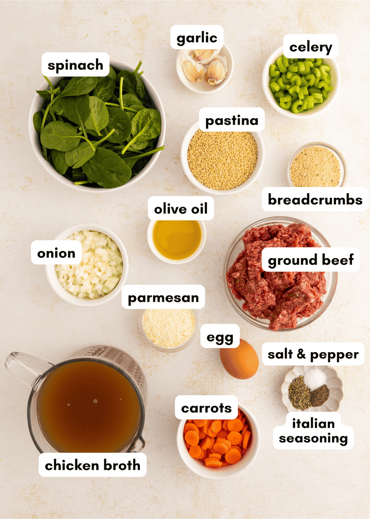 Italian Wedding Soup ingredients neatly labeled and arranged on a white surface.