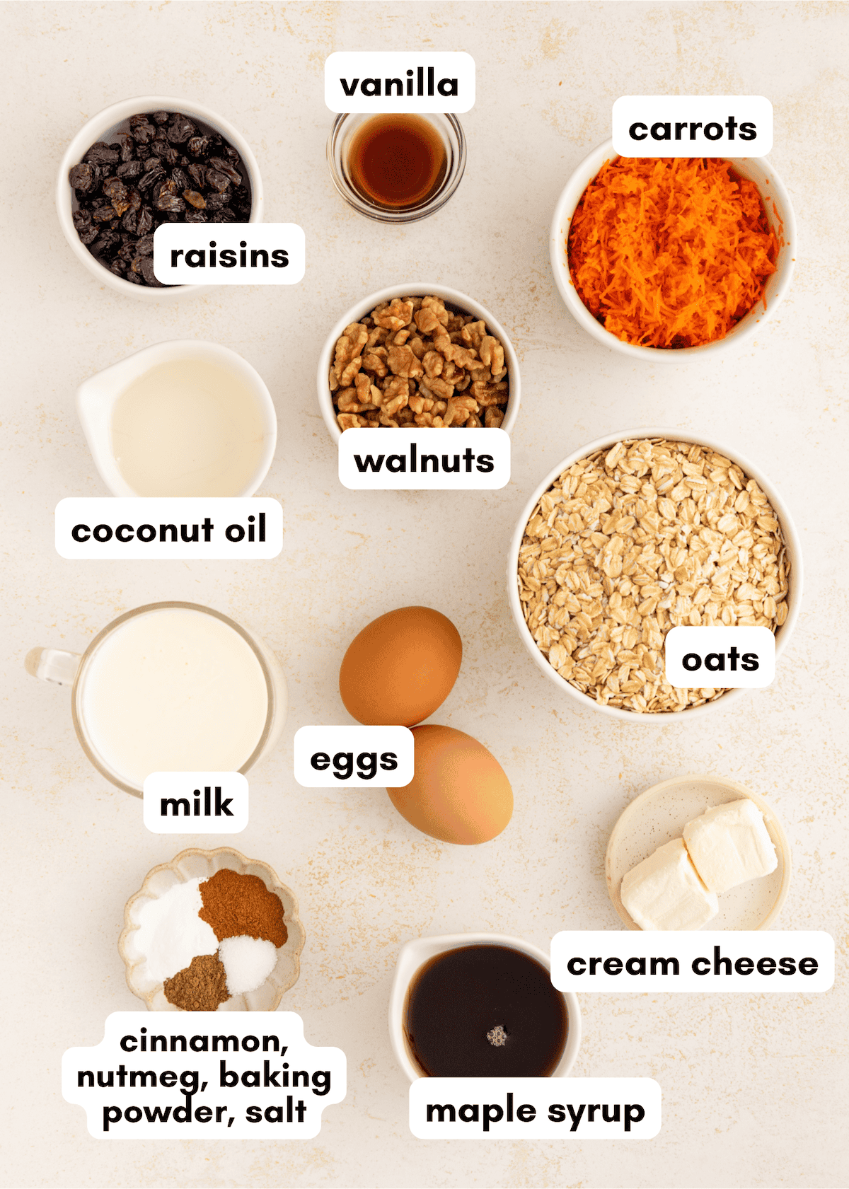 Bowls of carrot cake baked oatmeal ingredients, labeled oats, carrots, eggs, and cream cheese.