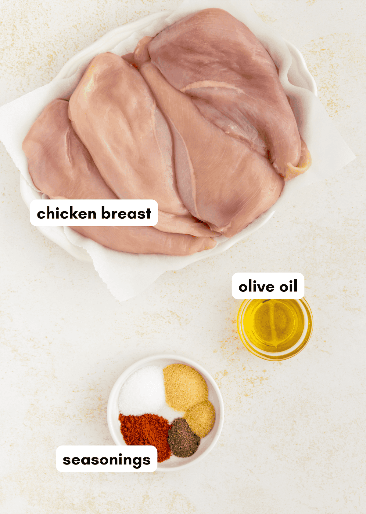 Air Fryer Grilled Chicken, olive oil, and seasonings arranged on a clean white surface.