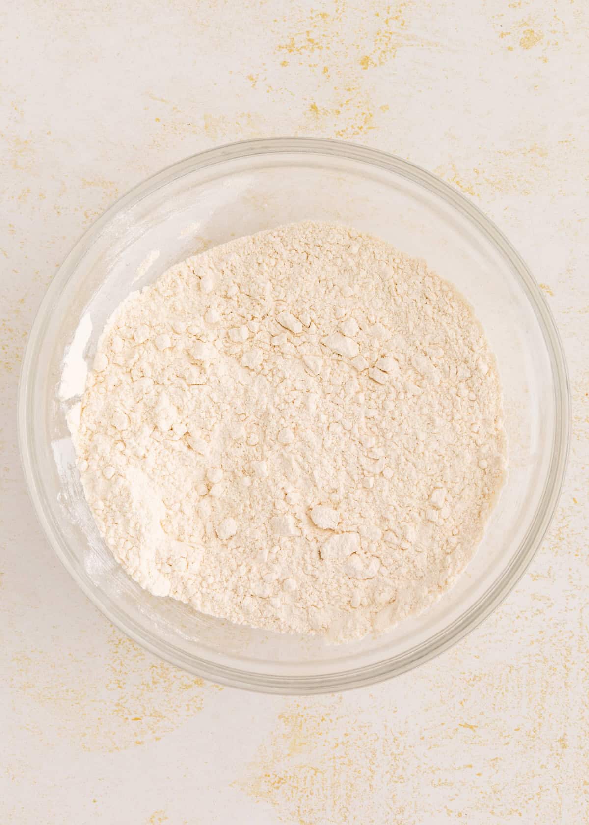 Bowl of gluten-free coffee cake flour mixture on a light-colored surface.