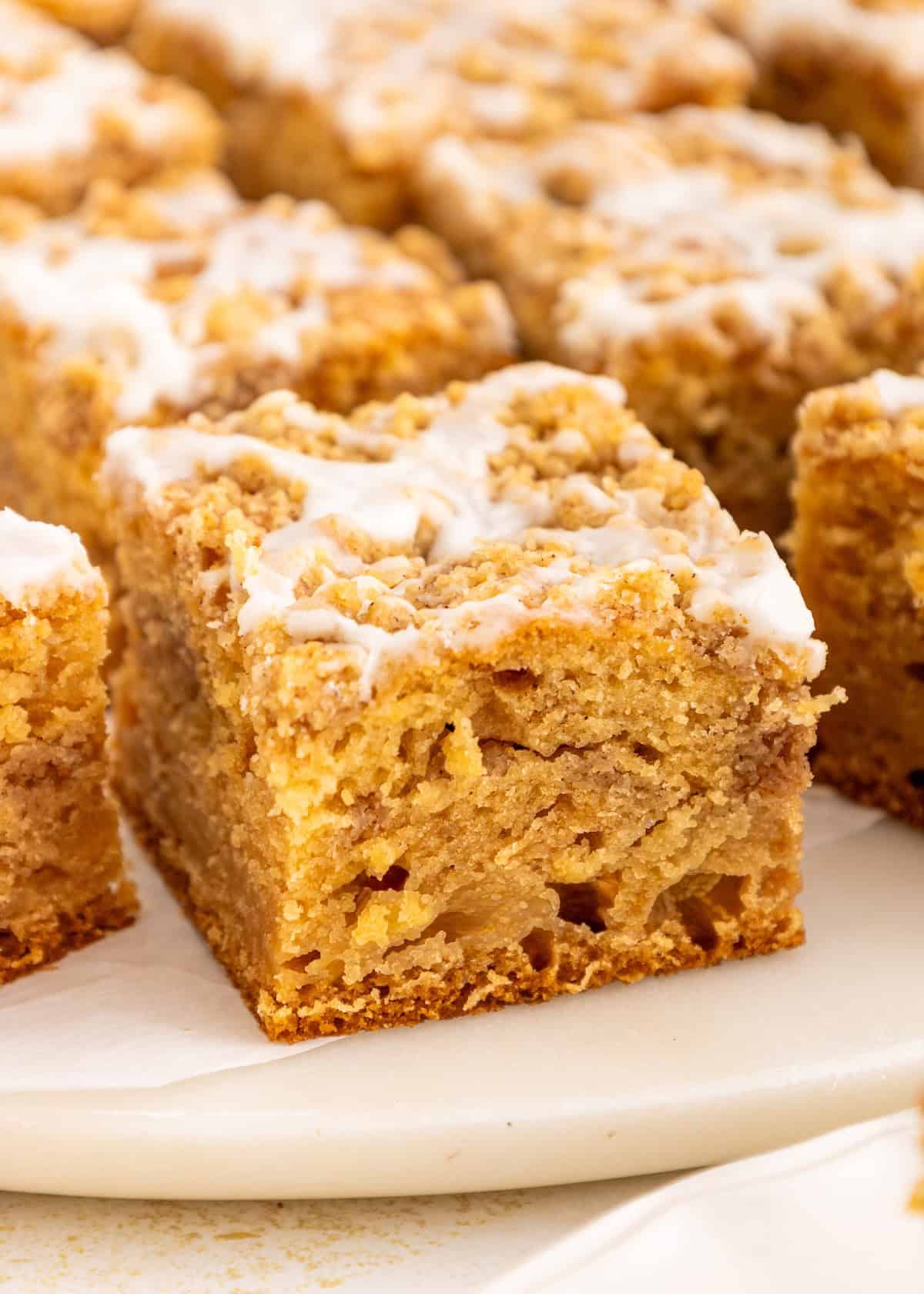 A close-up of a sliced gluten-free coffee cake with icing drizzled on top.