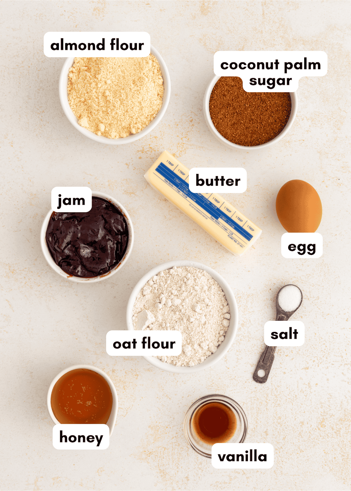 Baking ingredients for gluten-free thumbprint cookies: almond flour, oat flour, jam, honey, vanilla.