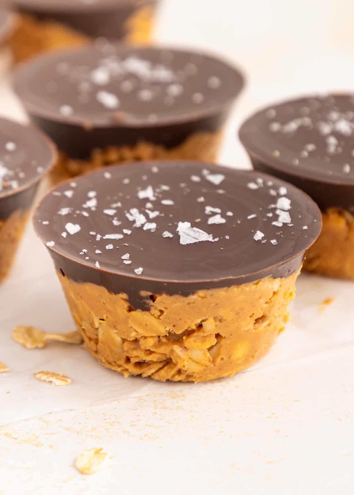 Peanut Butter Oat Cups topped with chocolate and sprinkled with flaky salt.