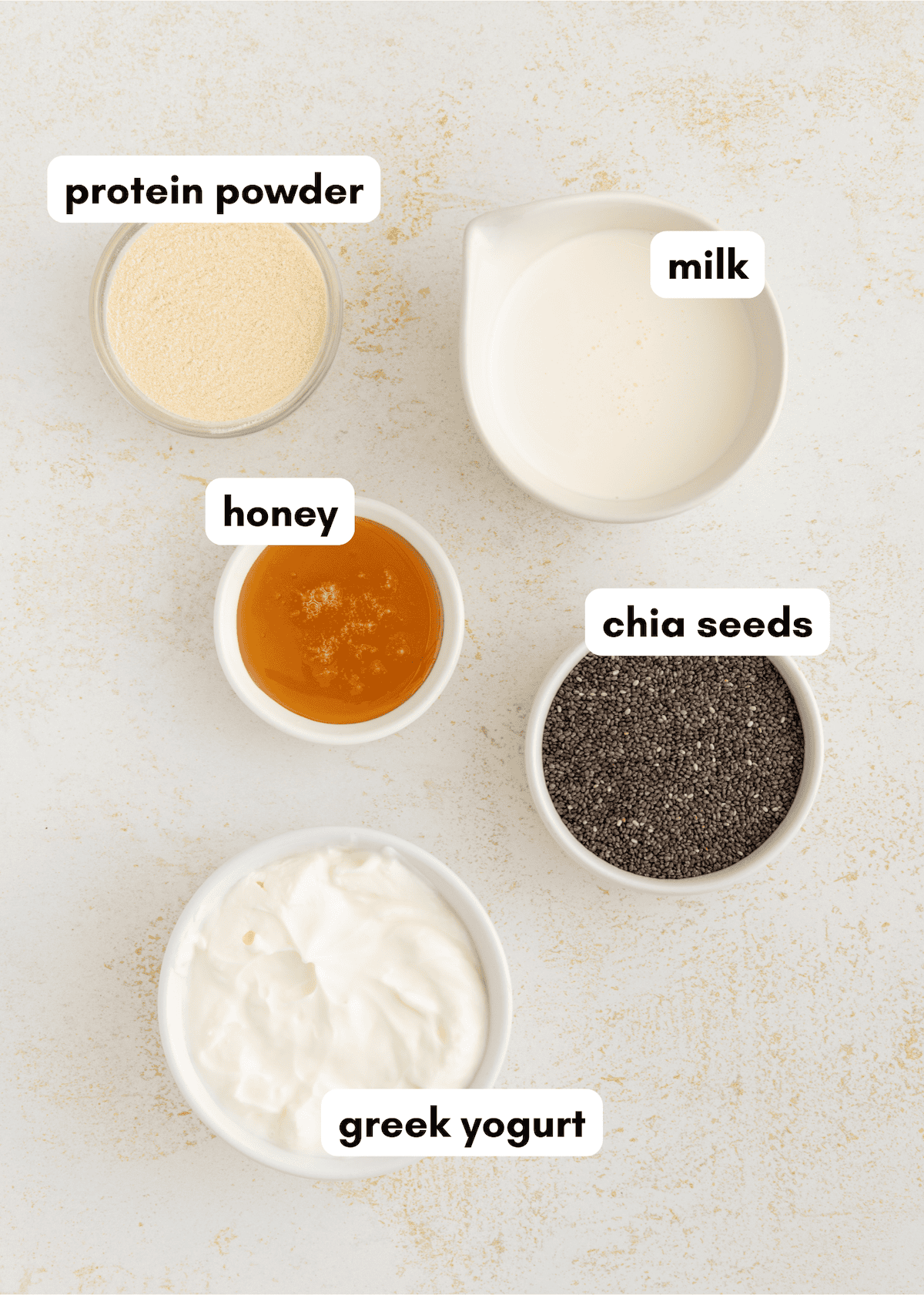 Five labeled bowls for Protein Chia Pudding: protein powder, milk, honey, chia seeds, yogurt.