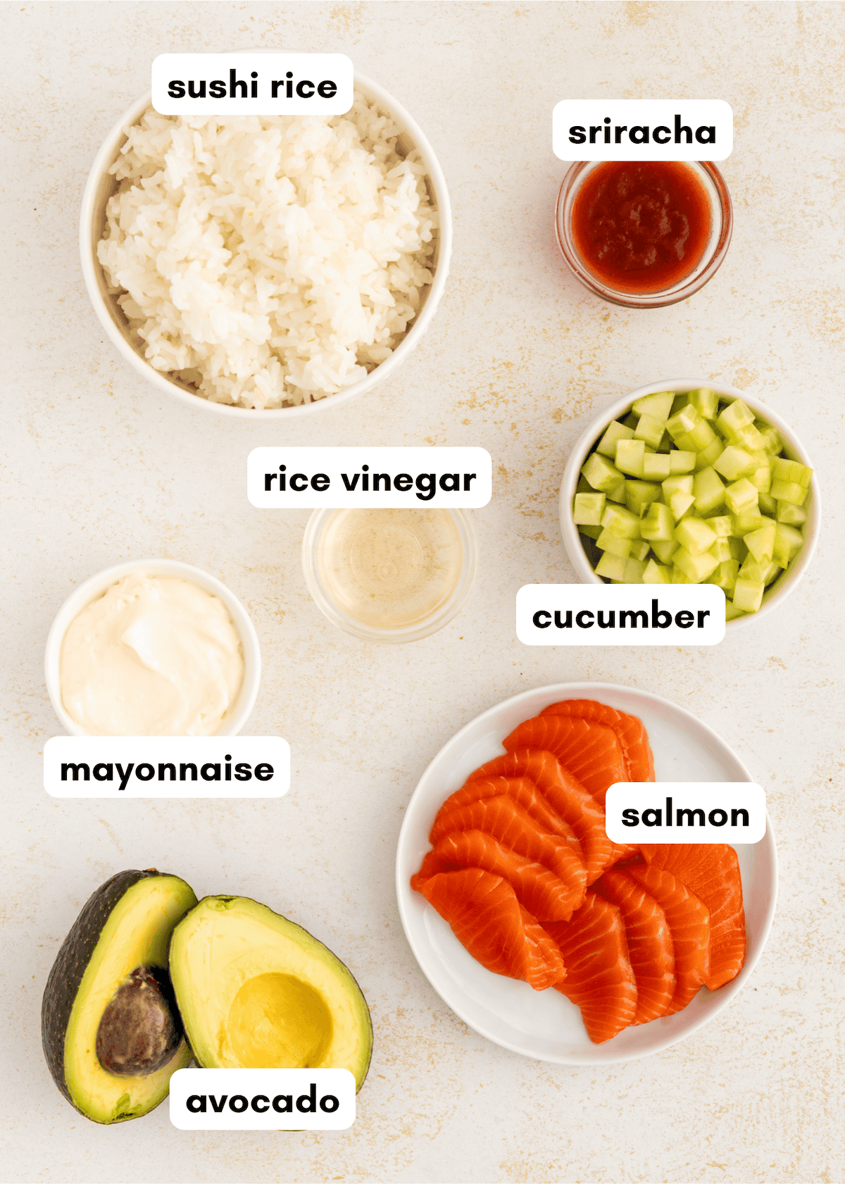 Bowls of sushi rice, sriracha, cucumber, salmon, mayo, and avocado for sushi stacks.