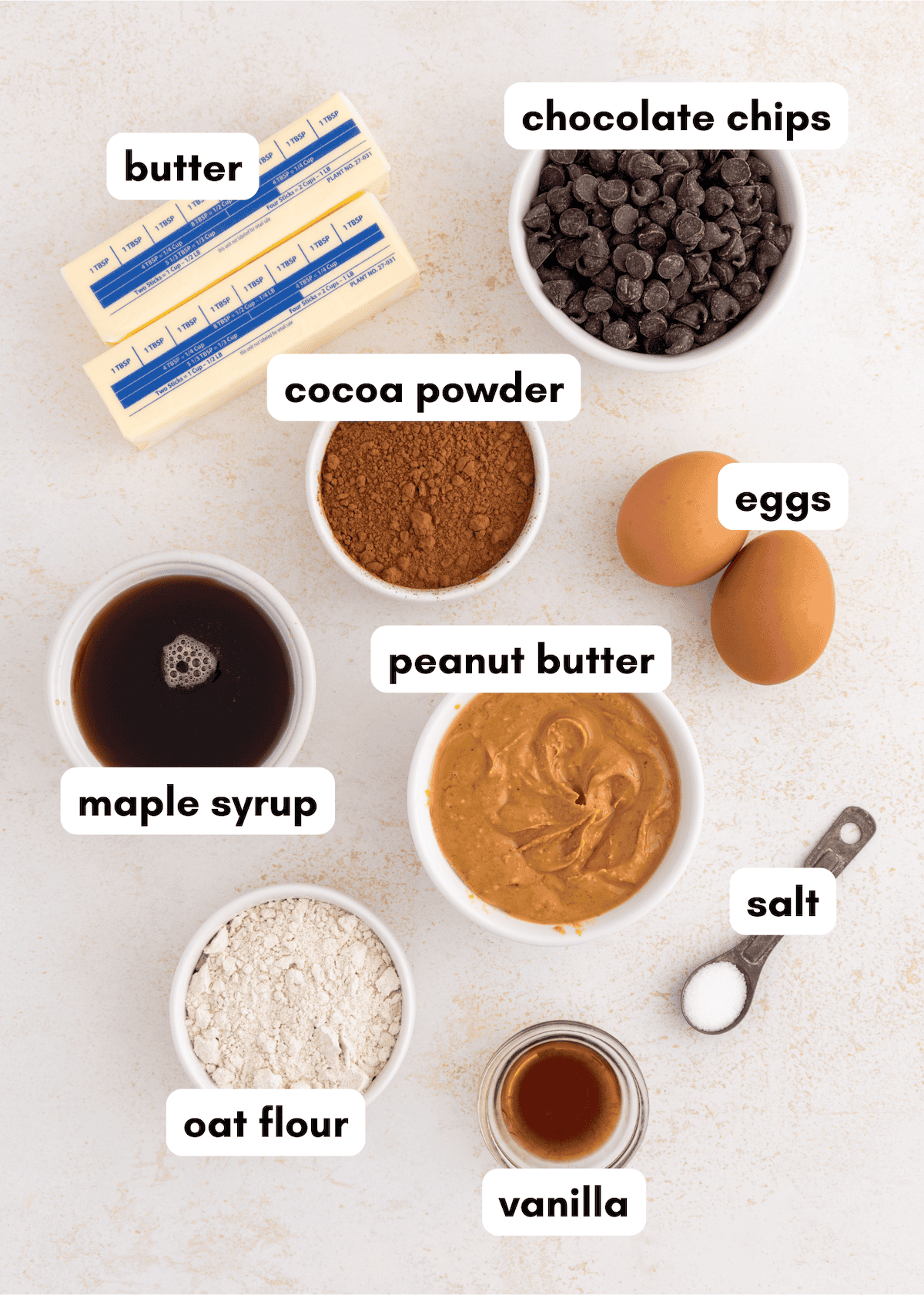Baking ingredients labeled: butter, chocolate chips, cocoa, eggs, maple syrup, peanut butter, salt, oat flour, vanilla.