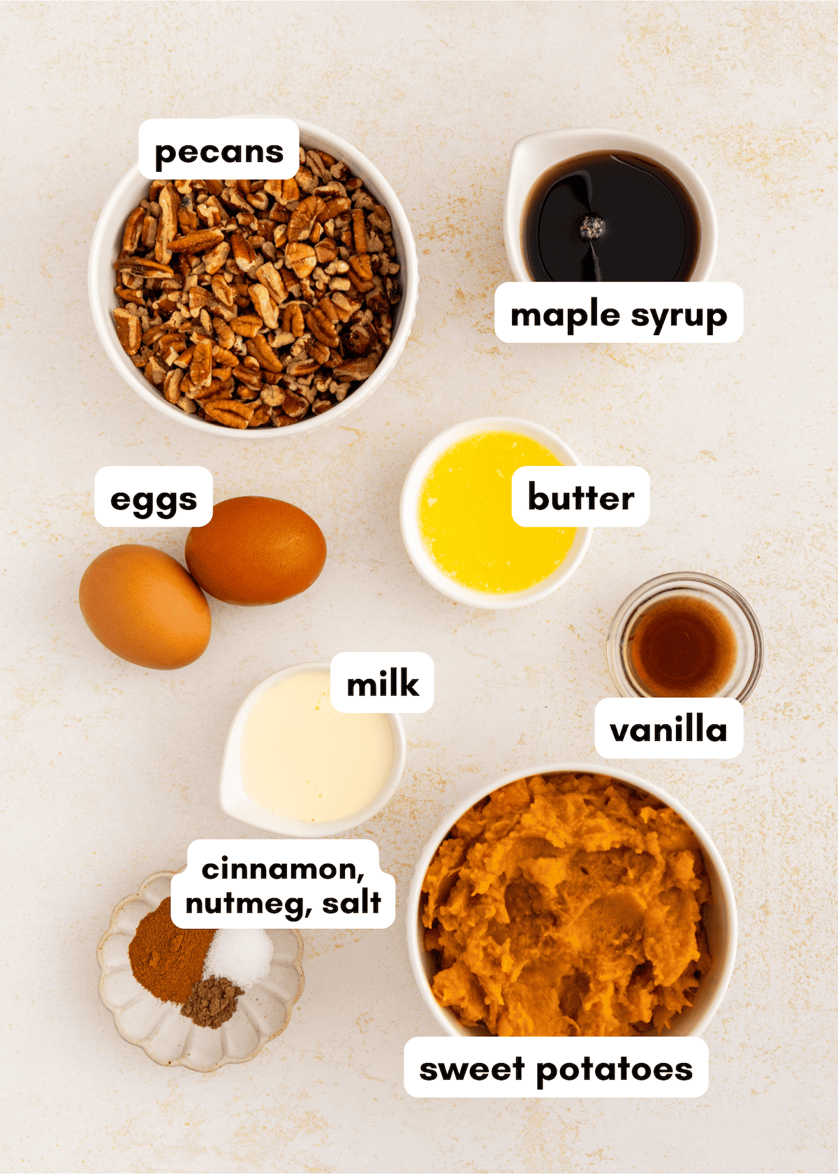 Bowls with ingredients for sweet potato pie bars: pecans, spices, eggs, butter, milk, and maple syrup.