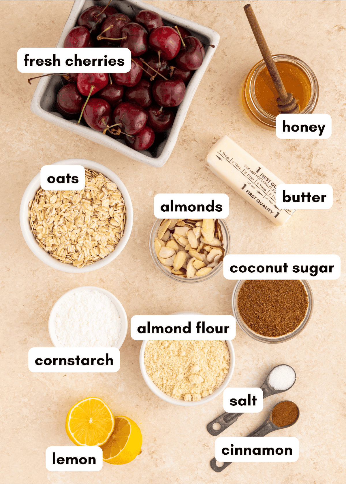 Ingredients for a gluten-free cherry crisp arranged on a counter, each labeled with its name.