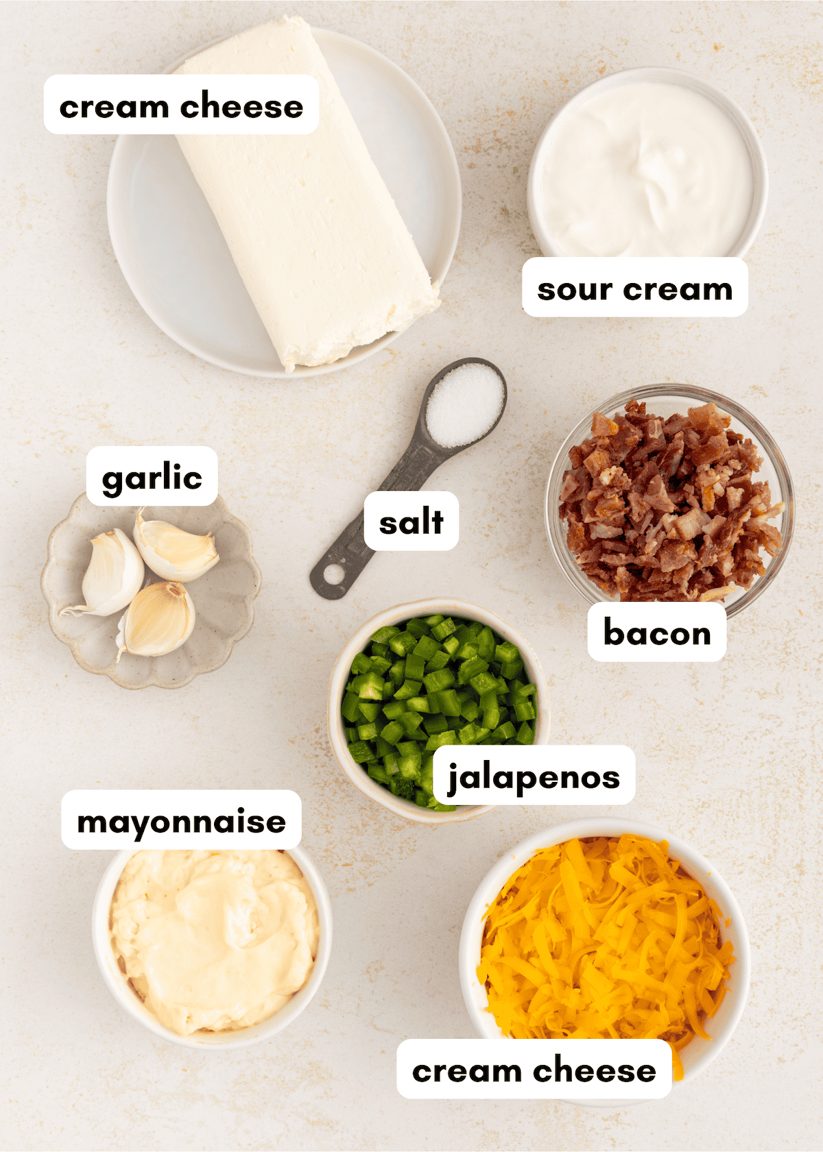 Ingredients for a recipe: cream cheese, sour cream, bacon, garlic, salt, jalapenos, mayonnaise, cheddar.