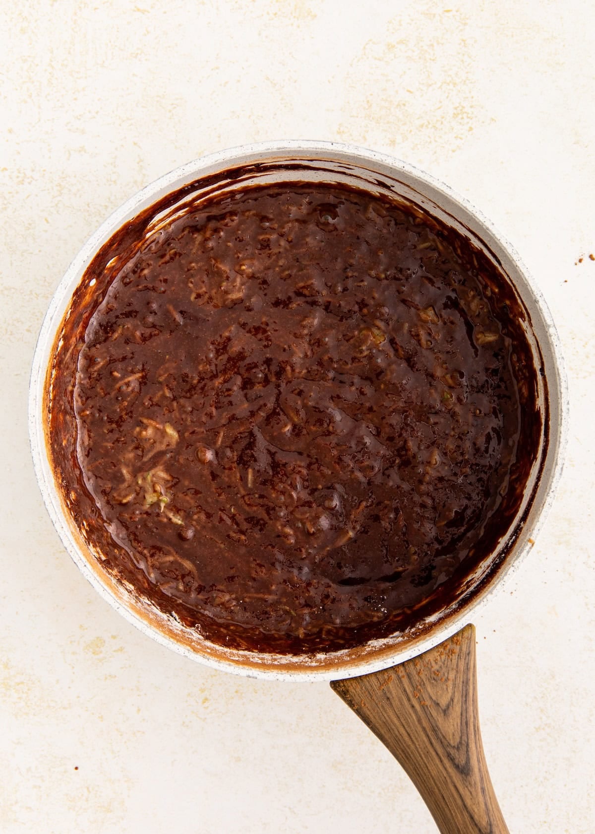 A saucepan with thick, dark chocolate mixture, seen from above.