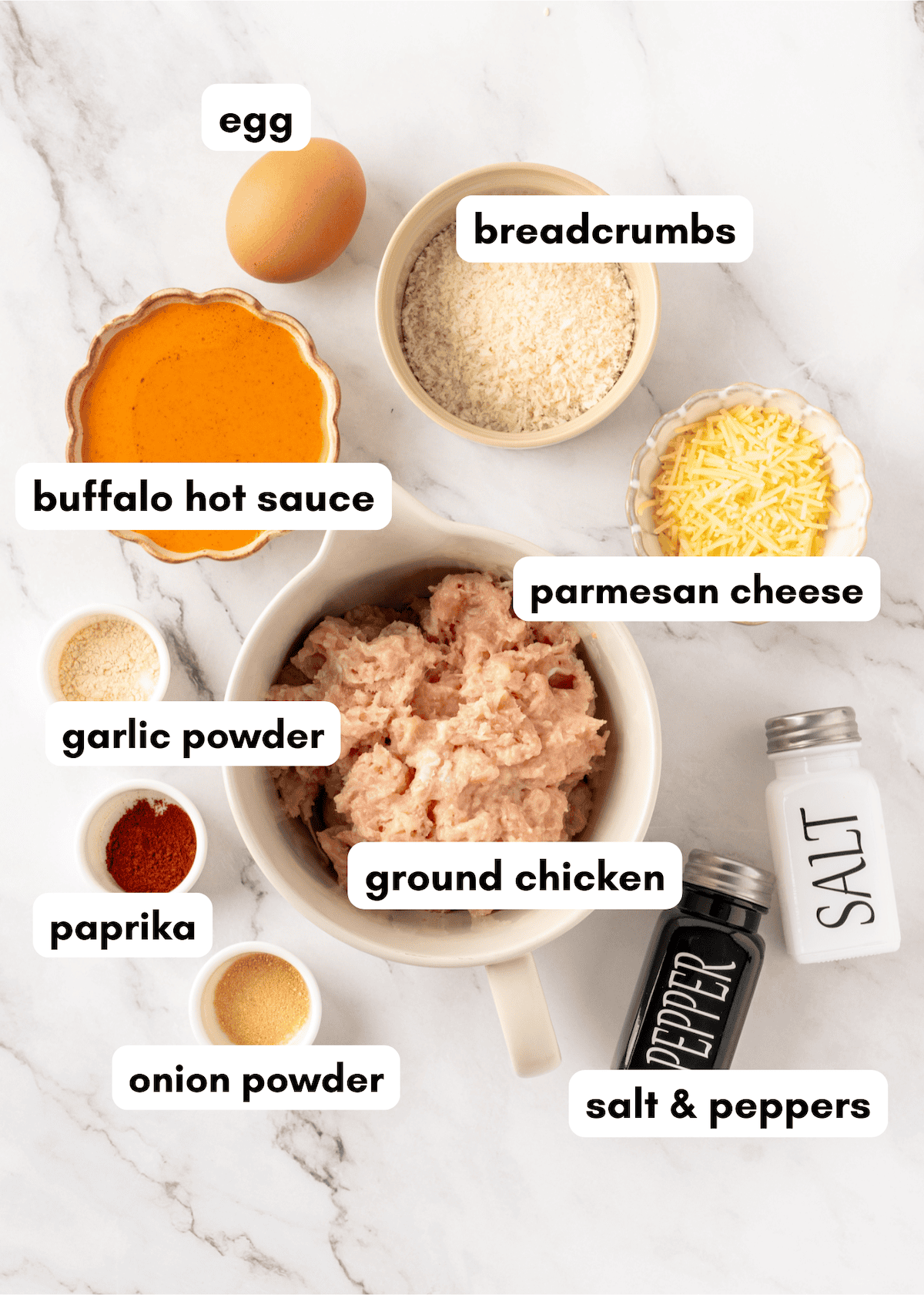 Ingredients for ground chicken including buffalo sauce, breadcrumbs, cheese, and spices.